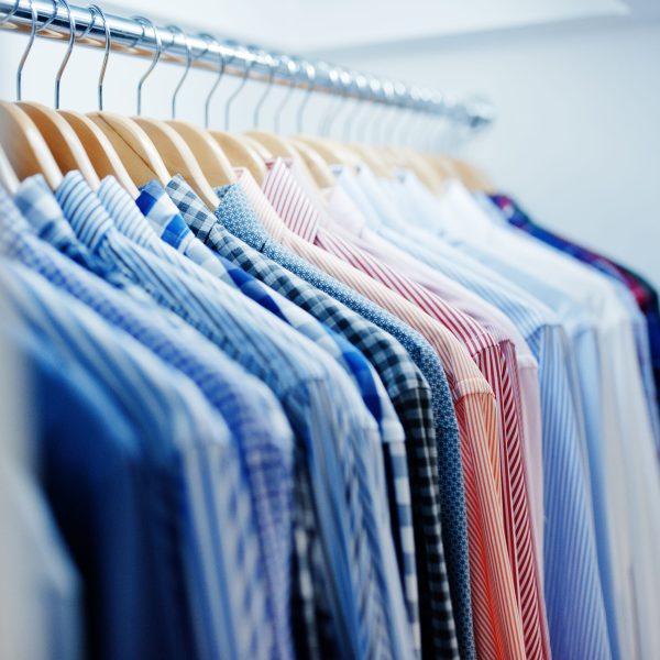Close-up photo of fashionable clothes on hangers in the shop.